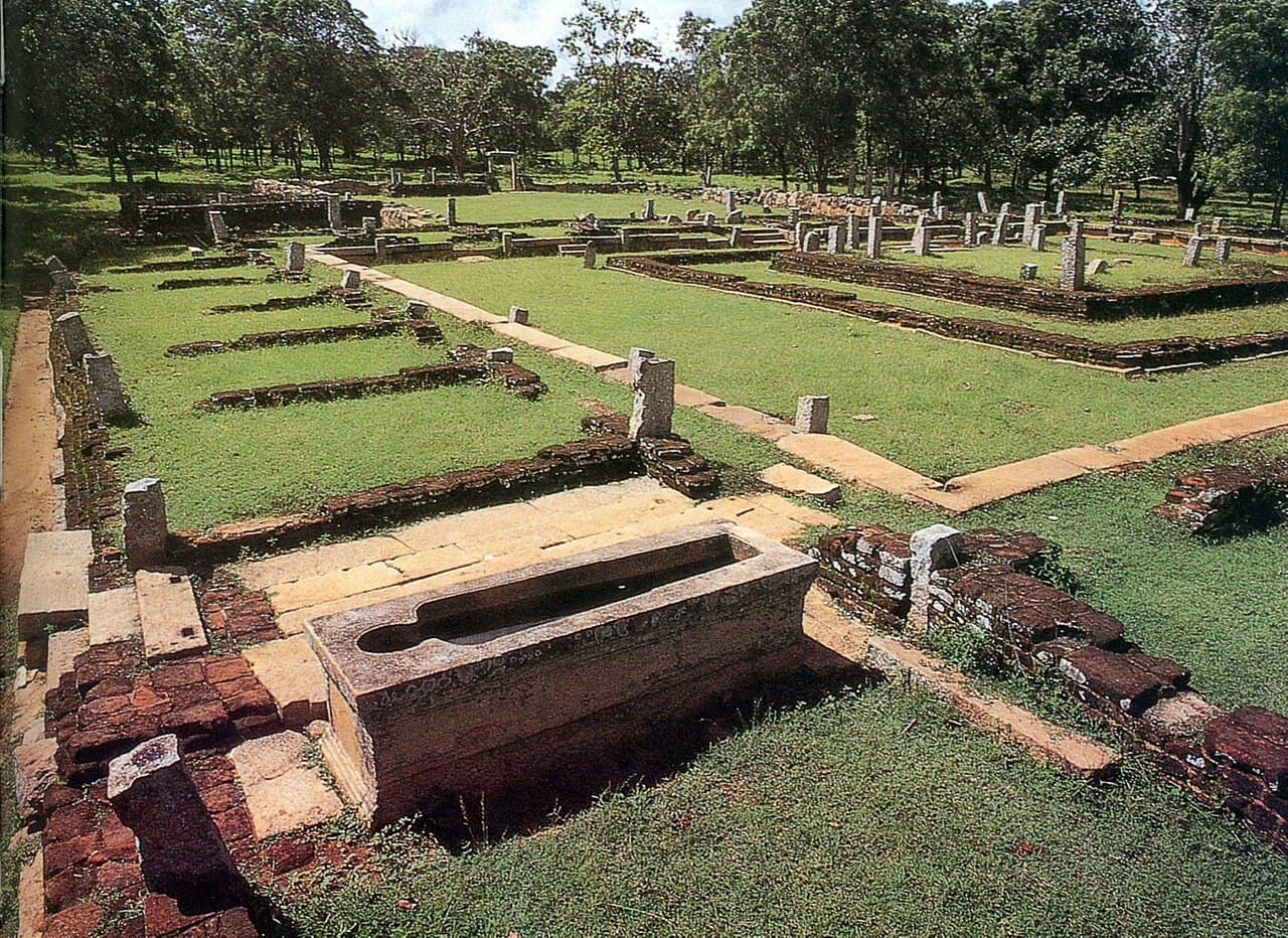 Excavated walls and the stone medicine trough at the Mihintale hospital complex