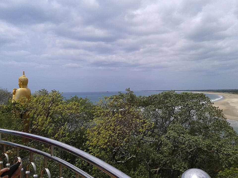 The gilded Buddha and the bay seen from the Lankapatuna temple terrace