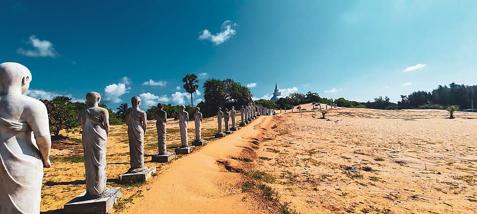 A line of stone figures leading over the dunes to the stupa at Muhudu Maha Viharaya, Pottuvil