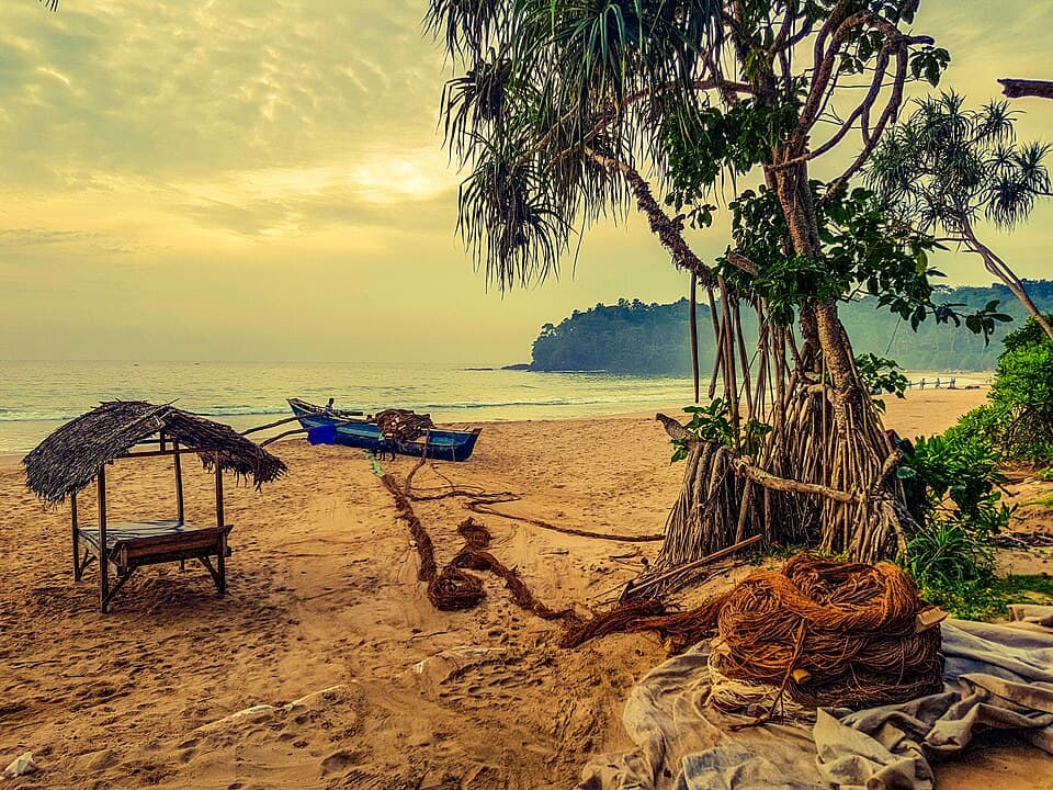 Talalla Beach at dawn, with a fishing boat and nets on the sand